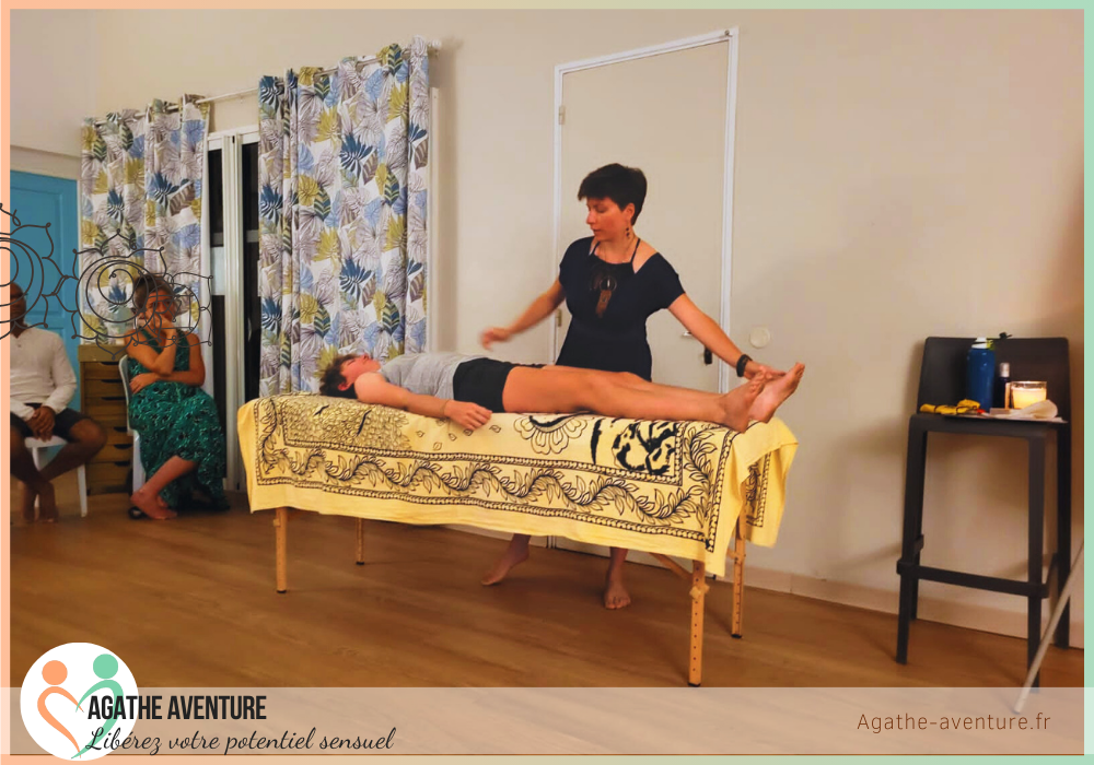Agathe Aventure en train de faire une démonstration de massage tantrique à la salle seconde vie réunion pour sa conférence, table de massage, paréo orange avec bouddha